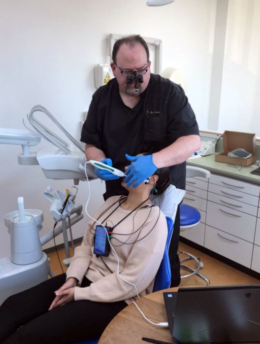 Doctor Ben Sutter using a pen like device to scan a patients jaws