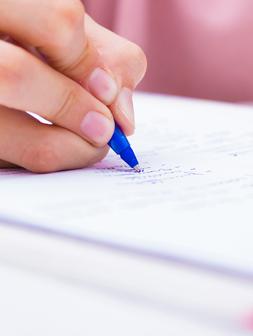 Person filling out paperwork in blue pen