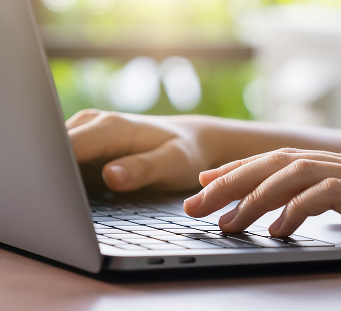 Close up of hands typing on a laptop